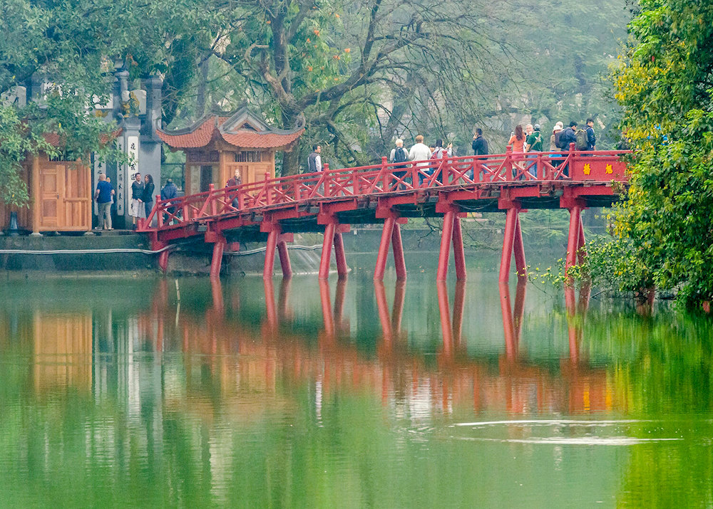 Ngoc Son Temple welcomes visitors to explore its sacred halls via the iconic red bridge over Hoan Kiem Lake