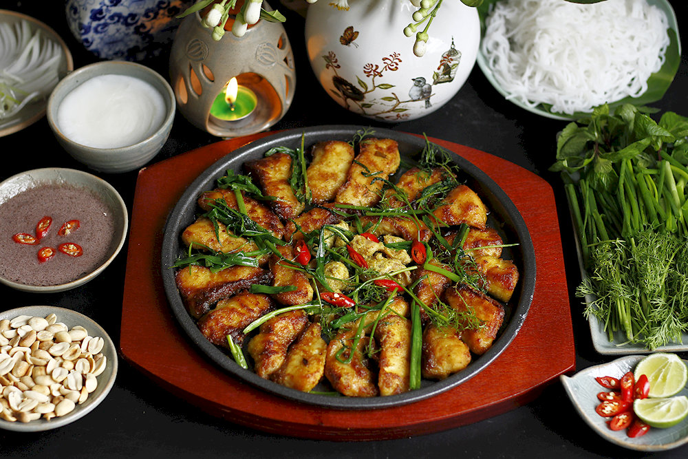Cha Ca La Vong serves up Hanoi’s iconic turmeric fish dish in a sizzling, herb-filled skillet