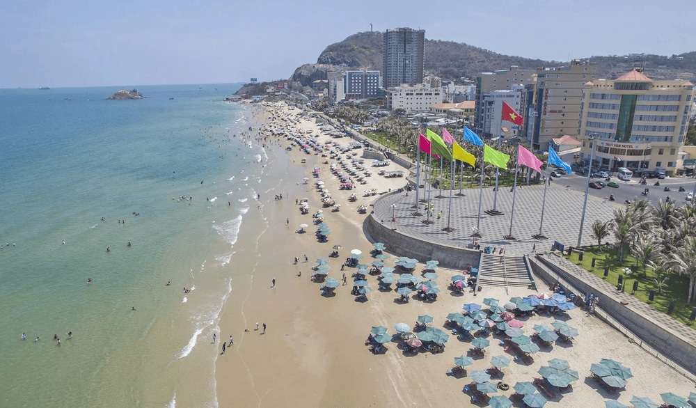 Back Beach's 8-kilometer golden sand coastline lined with modern resorts and traditional fishing boats creating perfect contrast