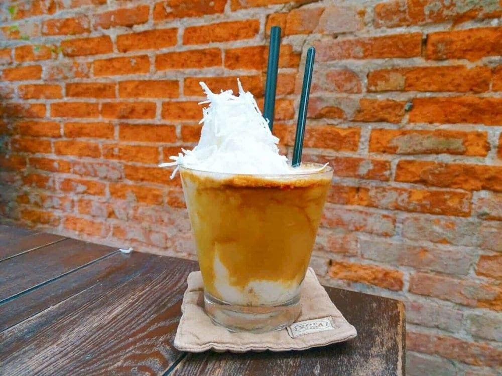 A creamy coconut coffee served cold, topped with coconut cream and enjoyed in a Hanoi café