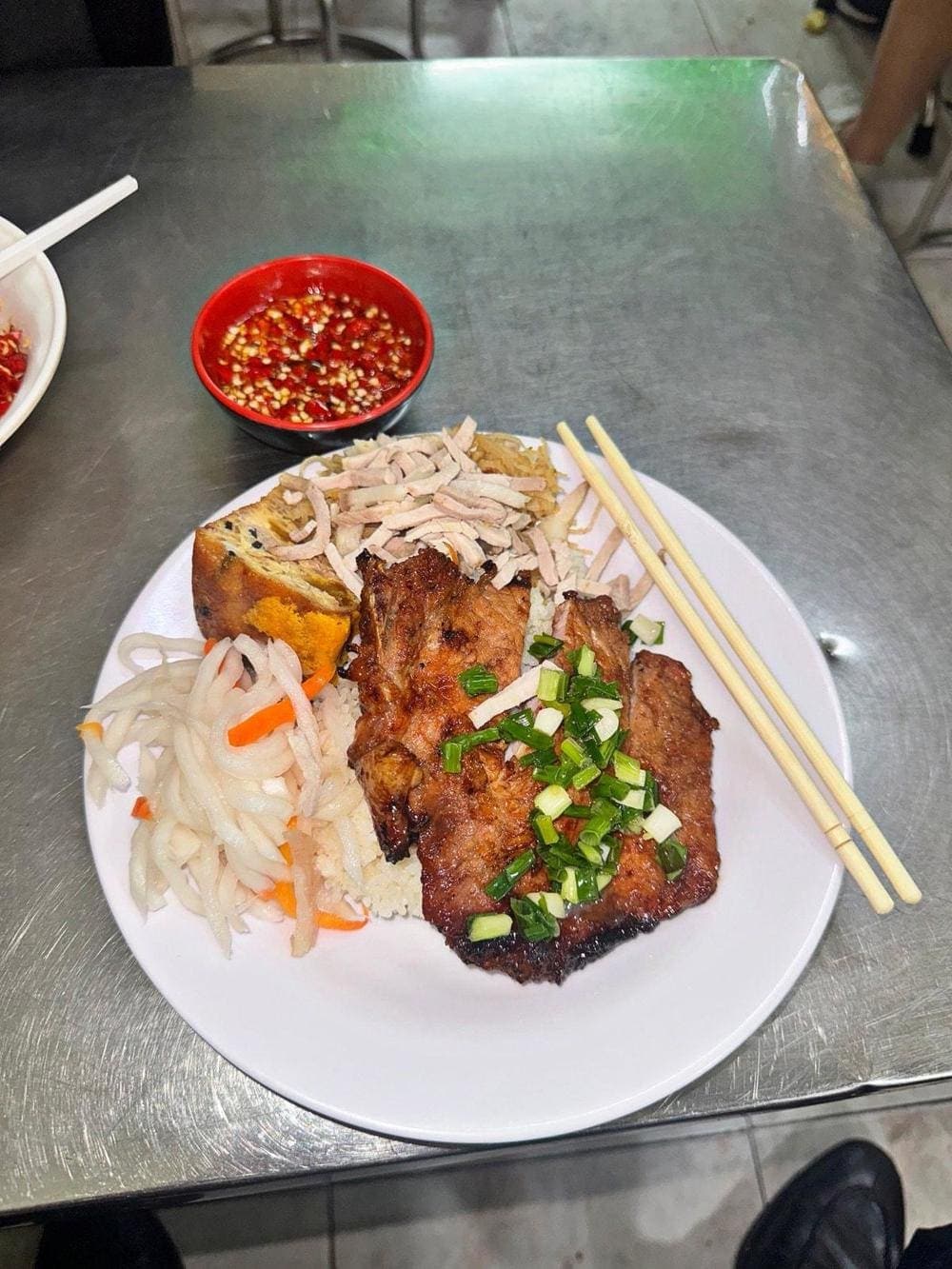Busy street food stall in Ho Chi Minh City serving local Vietnamese dishes