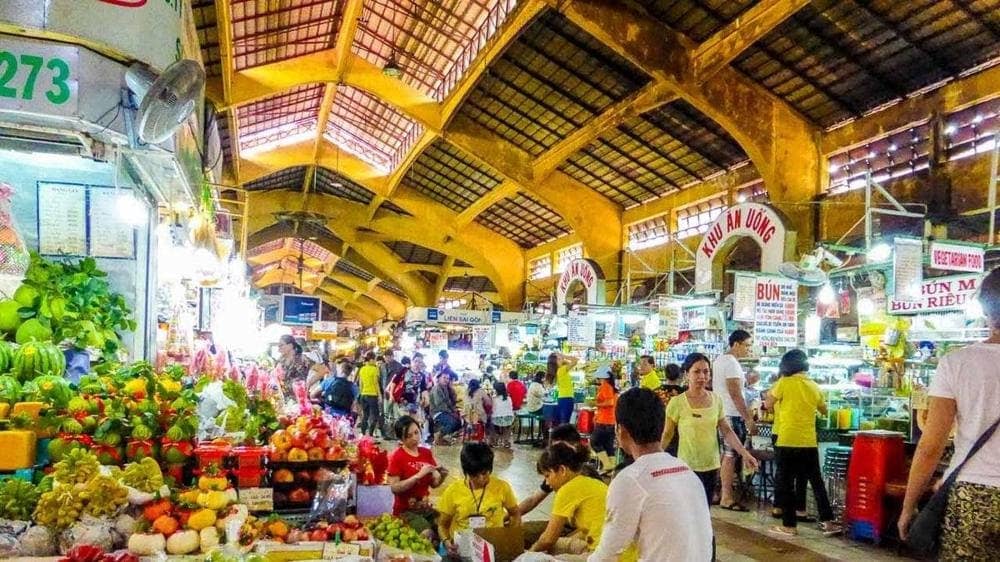 Local Vietnamese market vendor selling fresh vegetables and fruits