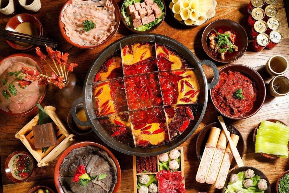 Chinese hot pot with bubbling broth, meats, and fresh vegetables