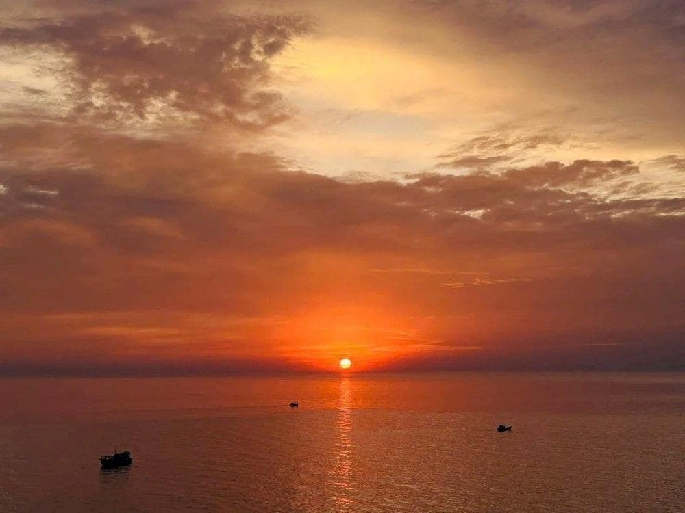 Sunsets from Hon Ngang paint the sky while boats drift across the sea
