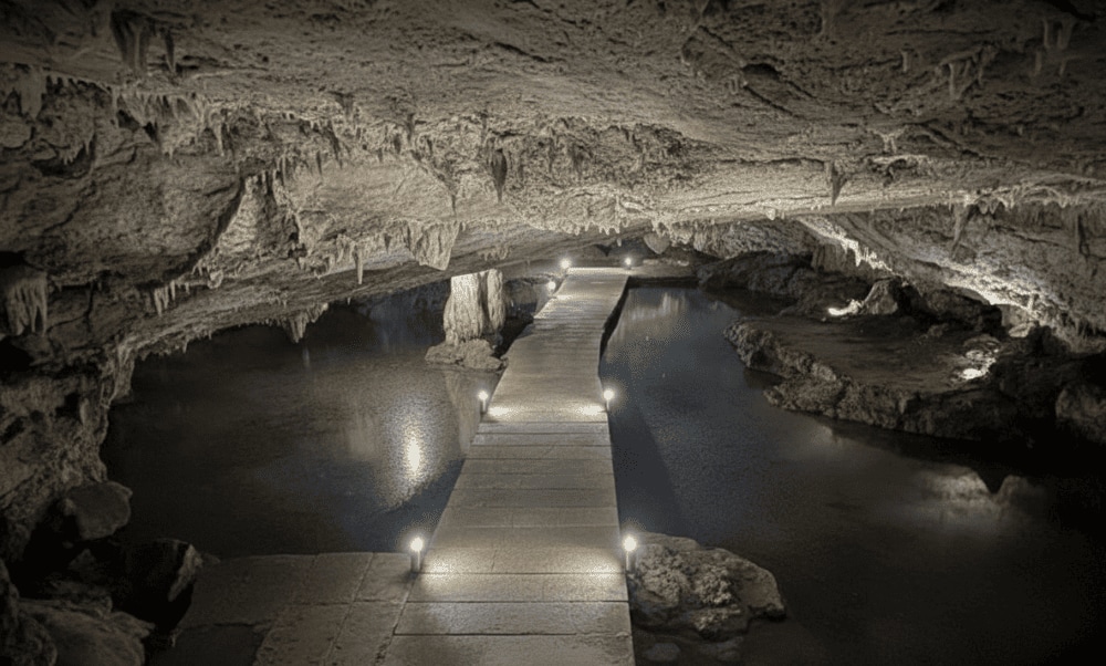 An underground stream flows gently through the cave, creating a cool and peaceful atmosphere