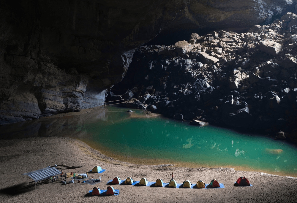 The expedition team sets up camp beside a tranquil underground river under Son Doong’s colossal ceiling (Source: Canva)