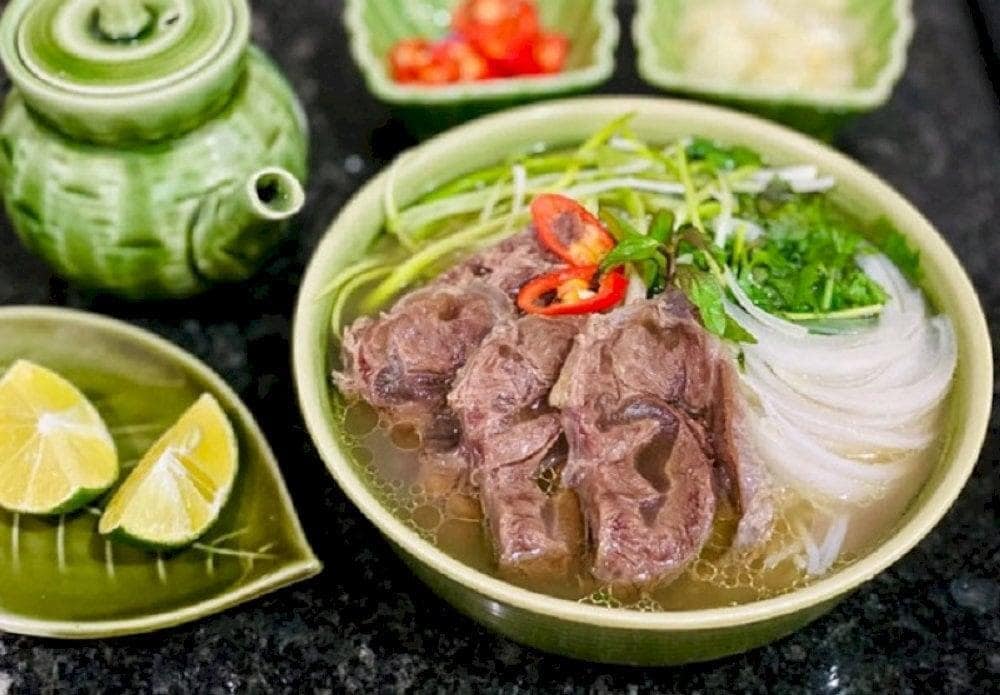 Pho is typically served with fresh herbs, bean sprouts, lime, chili, and sauces like hoisin or sriracha for added flavor