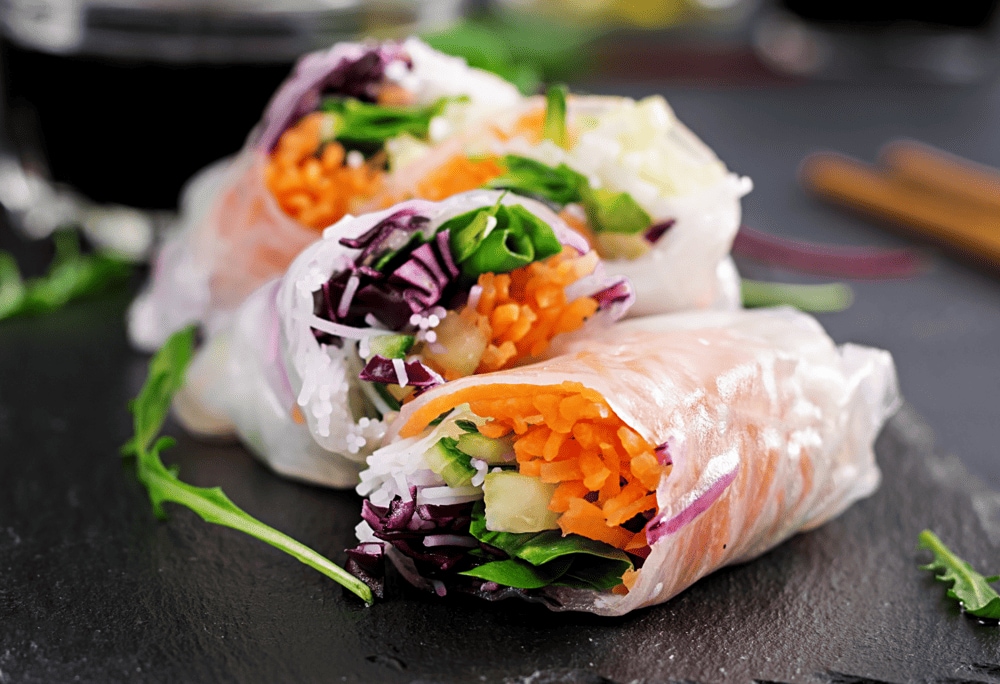 Enjoy vegetarian spring rolls with crispy sweet vegetables, fresh rice noodles, and tofu/mushrooms, dipped in irresistible sweet and sour sauce (Source: Canva)