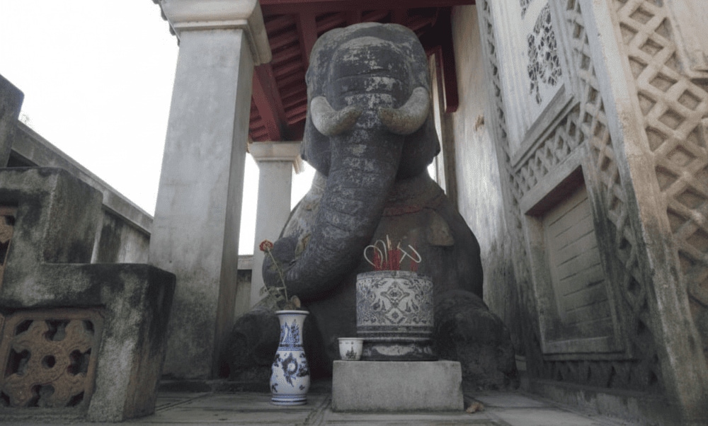 Two kneeling stone elephants guard the entrance, giving the temple its name, 'Voi Phuc’