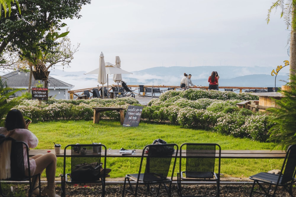 Quán trang trí theo phong cách đậm chất thiên nhiên với nhiều tiểu cảnh như xích đu gỗ, hoa tươi (Nguồn: Fanpage Tiệm cà phê Trên Đồi Có Mây)