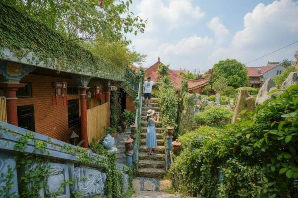 Cầu thang đá tự nhiên, xung quanh có nhiều cây cảnh xanh mướt, mang đến cảm giác bình yên, gần gũi với thiên nhiên.