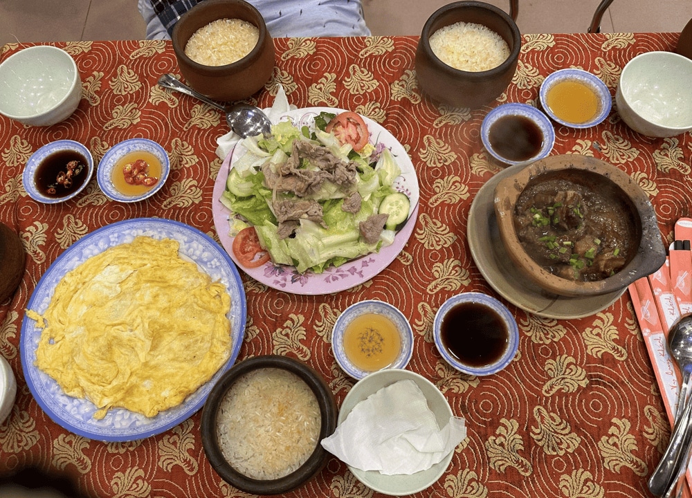 Cơm niêu Đà Lạt ăn kèm với trứng chiên, thịt kho, salad, v.v. (Nguồn ảnh: Fanpage Cơm niêu Vĩnh Ký)