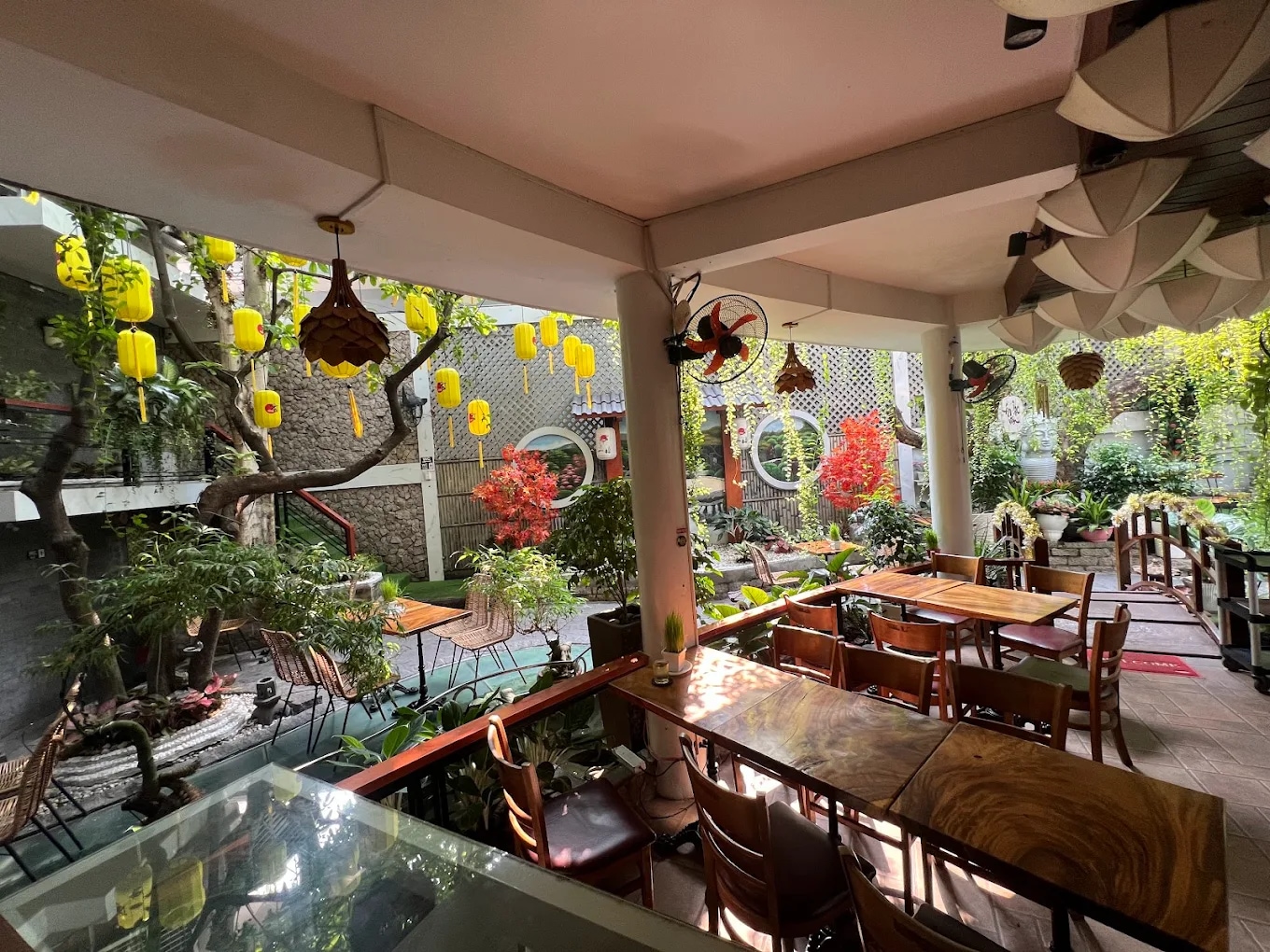 Zenhouse offers a tranquil atmosphere with koi ponds, greenery, and a central prayer tower that evokes a sense of inner peace