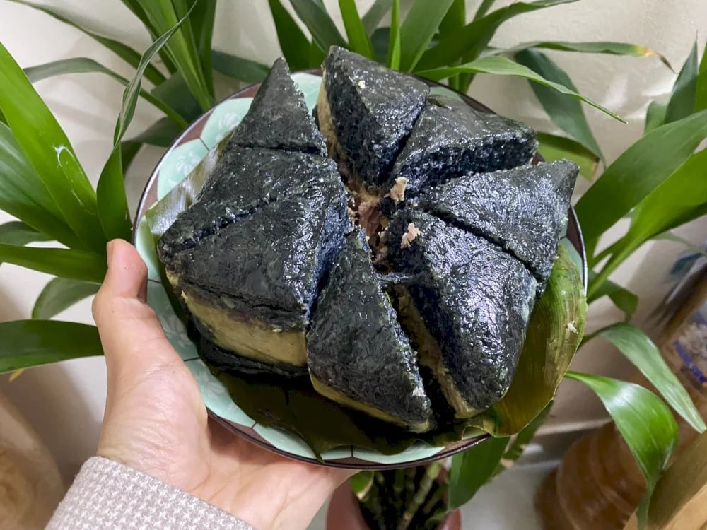 The filling combines tender pork and creamy mung beans, wrapped in fragrant black sticky rice, creating a rich, earthy flavor with a subtle smoky finish 