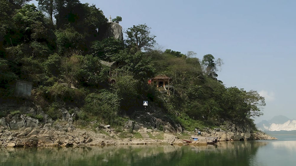 The entrance to Thuy Tien Cave, shaded by vines and ancient stone