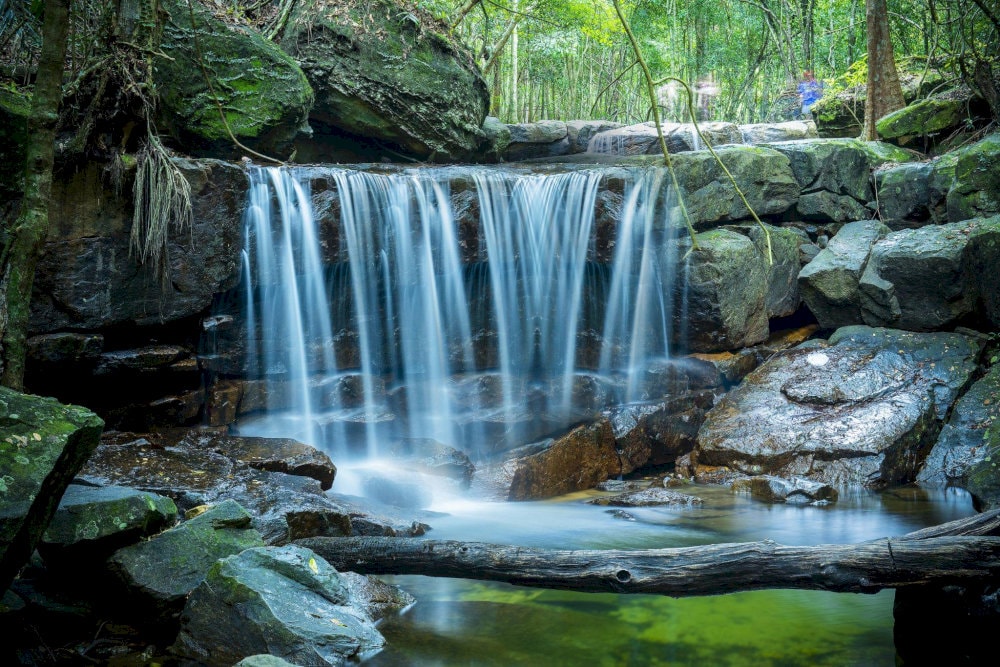 Suoi Tranh Waterfall presents a picturesque cascade formed by mountain springs that flow through lush greenery and limestone rocks 