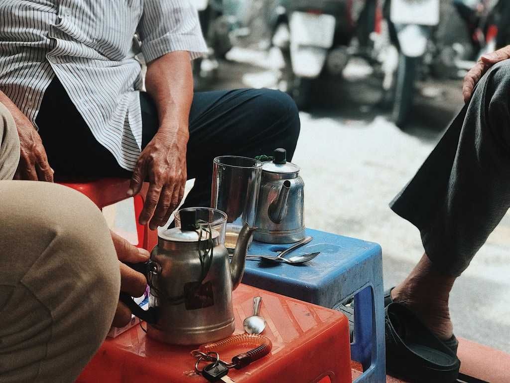 Vietnamese elderly man enjoying morning coffee at a street-side cafe