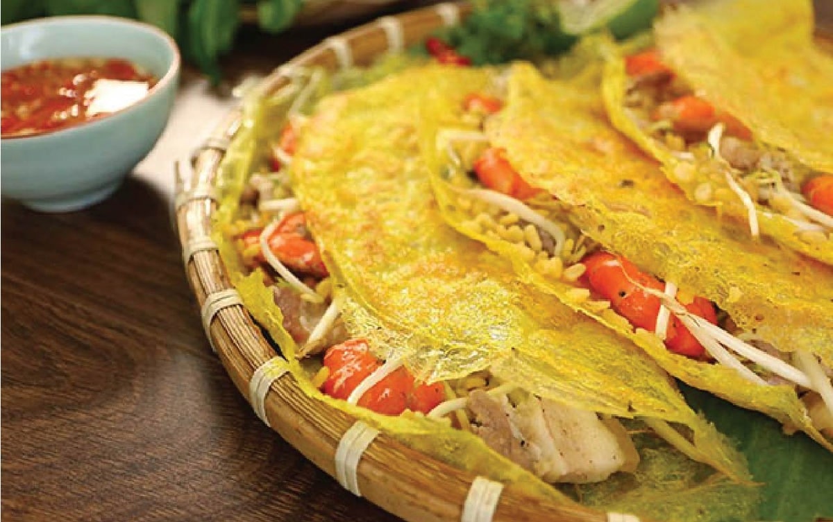 Bánh xèo với lớp vỏ vàng giòn, nhân đầy ụ ăn kèm rau sống và nước mắm chua ngọ
