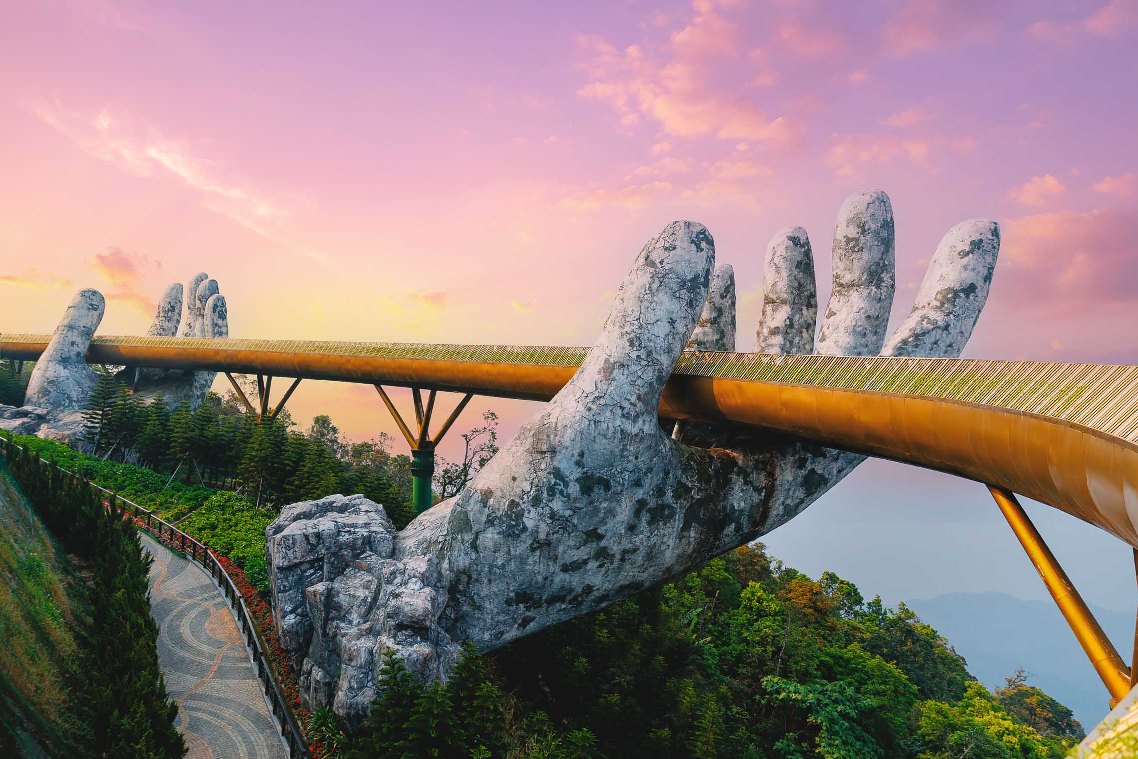 Golden Bridge at Ba Na Hills, Da Nang, with giant stone hands supporting the curved bridge above the clouds