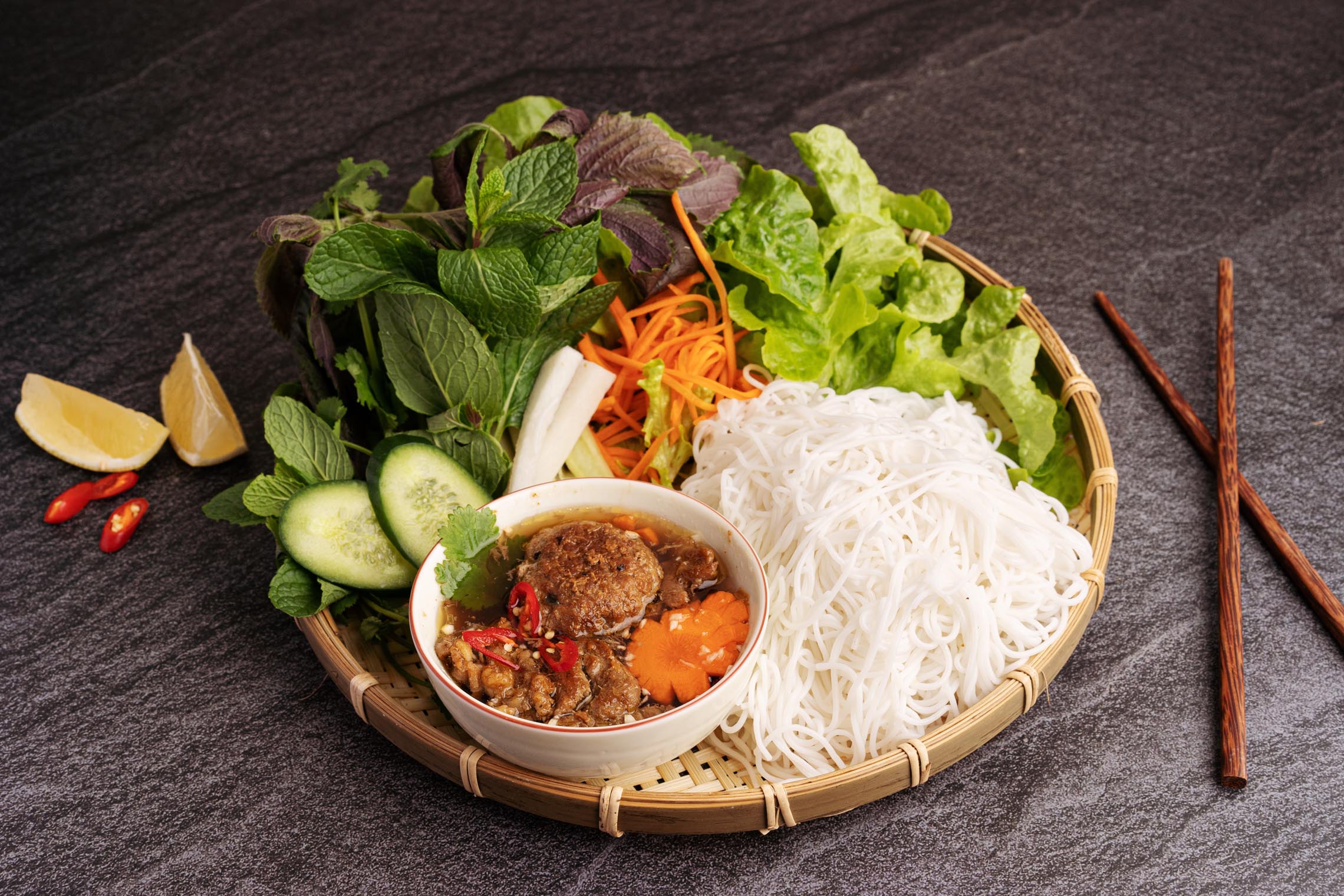 Bun Cha, one of Hanoi's most celebrated specialties, perfectly pairs charcoal-grilled pork with fresh rice noodles and a signature sweet-and-sour dipping broth