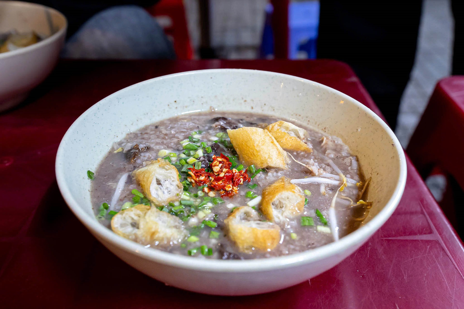 Tô cháo khói bốc nghi ngút, điểm xuyết lòng heo, dồi, gan và hành tiêu 
