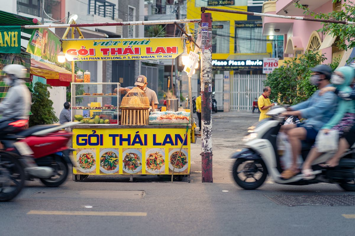 The bustling street of Phan Xich Long with food trucks on sideways