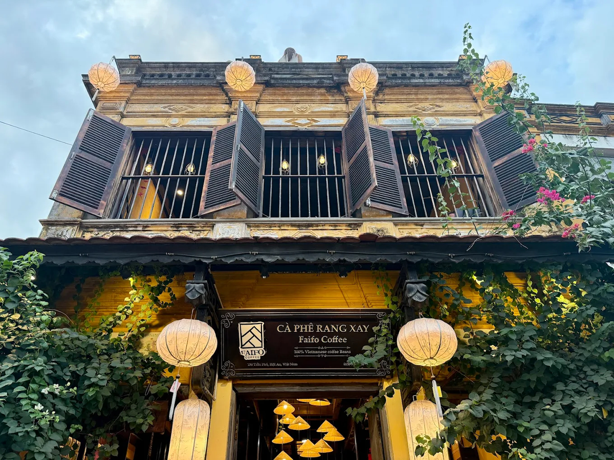 Faifo Coffee nổi bật với tường vàng và cửa sổ gỗ cổ kính mang đậm chất Hội An