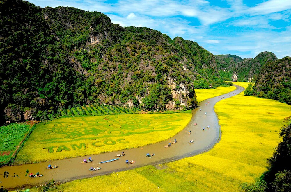 Tam Coc greets visitors with striking limestone cliffs and the peaceful Ngo Dong River weaving through rice fields