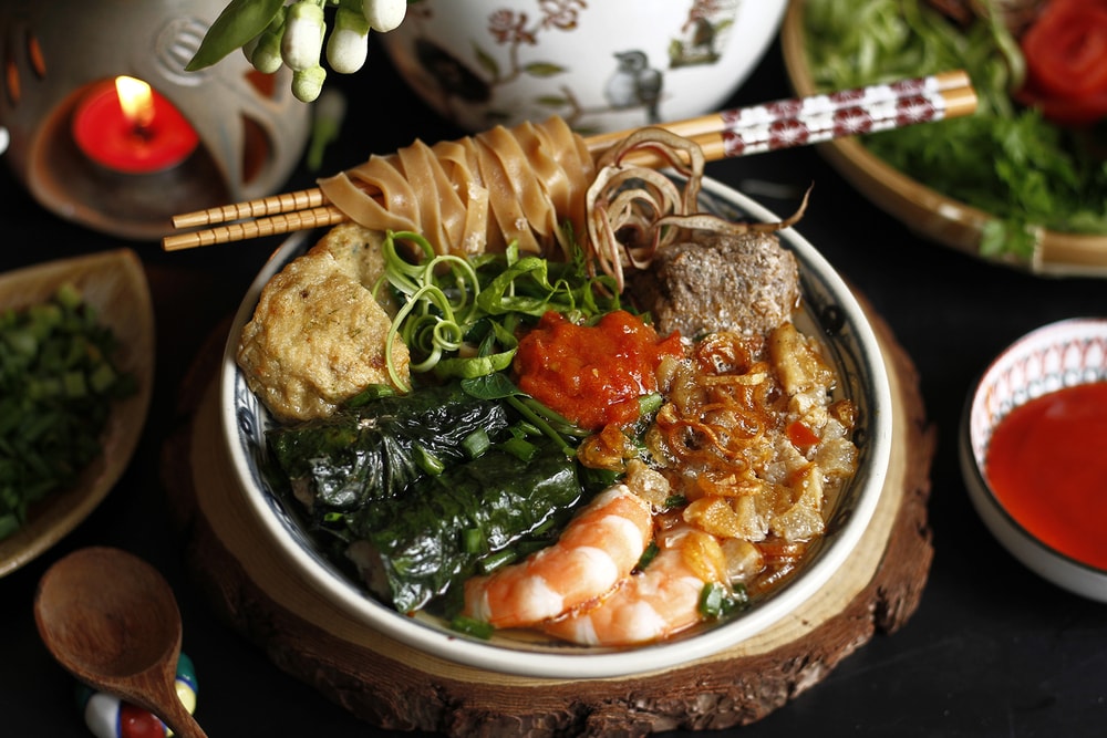 Một bát bánh đa cua Hải Phòng chuẩn vị với bánh đa đỏ dai ngon và nhiều loại đồ ăn kèm hấp dẫn